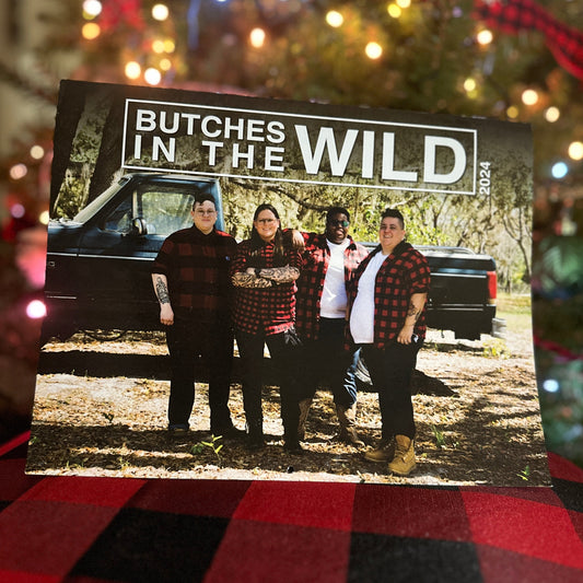 butches in the wild 2024 calendar on a buffalo plaid tablecloth in front of a lit christmas tree